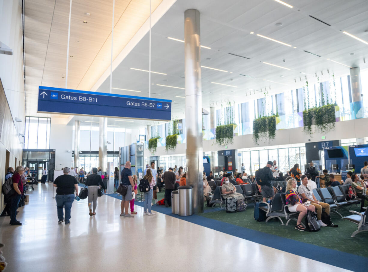 Travelers wait at their gates in the newly renovated and extended Concourse B, which reopened in late 2021 at Portland International Airport. PDX's new main terminal is under construction now and on track to open in 2025.