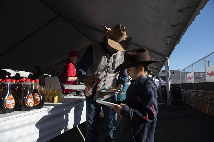 Sam Hernandez of Hockinson helps his son, Benjamin, with the syrup at the Clark County Fair on Friday.