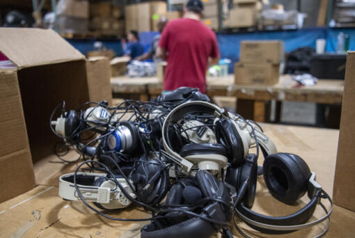 Headphones sit on a table before they are sorted and recycled. They will be disassembled and sorted by material before recycling.