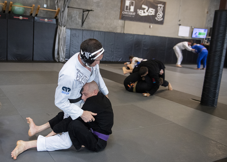 Brazilian jiujitsu instructor Chris Dealy, the owner of The Base in Vancouver, left, takes on Joshua Smith, who has been training in Brazilian jiujitsu for 15 years despite lacking full use of his legs.