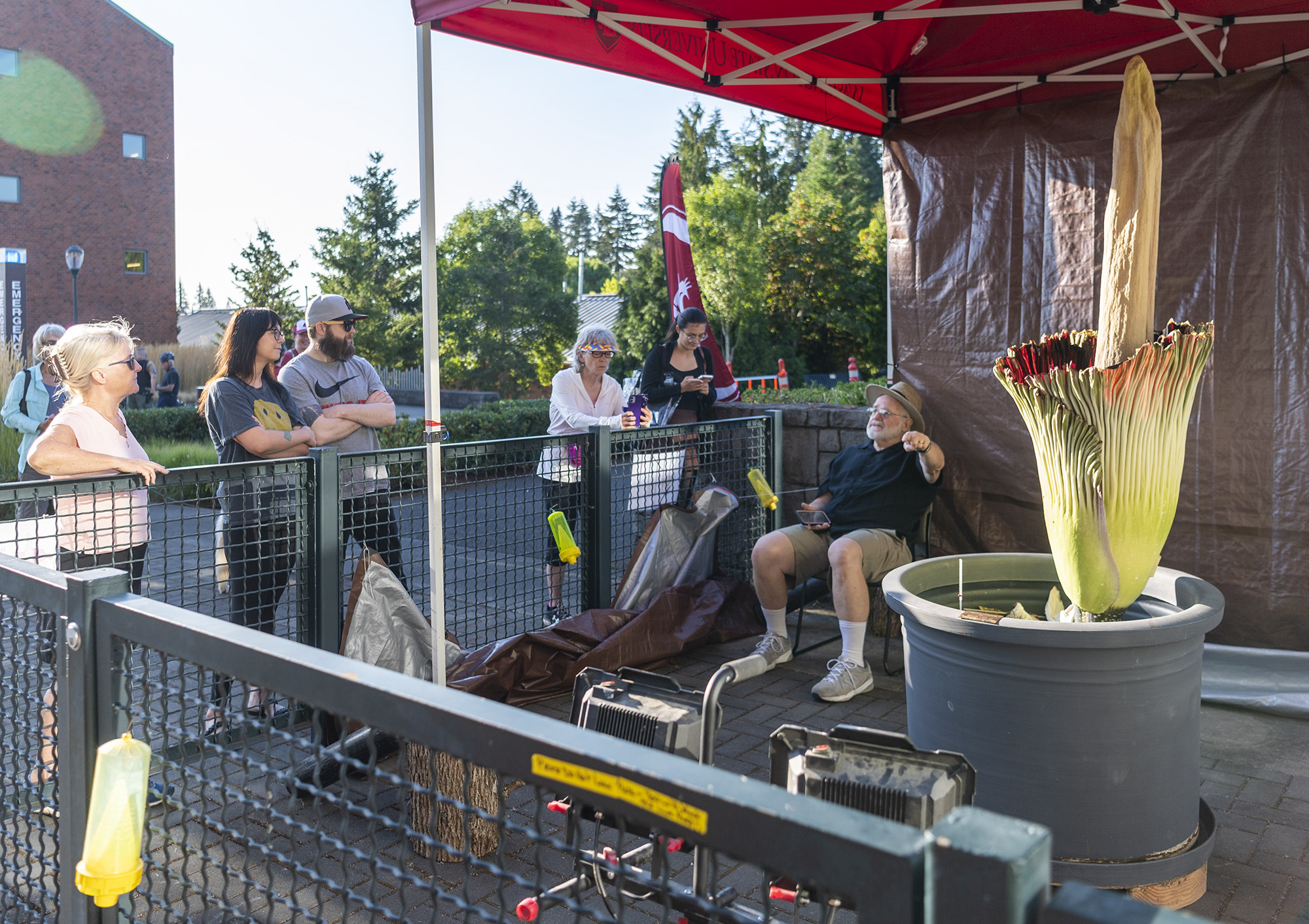Washington State University Vancouver Prof. Steven Sylvester, center, talks to onlookers about Titan VanCoug, a corpse flower, on Wendesday, Aug. 17, 2022, at Washington State University Vancouver. The rare flower only blooms for 24-48 hours. It last bloomed in 2019.
