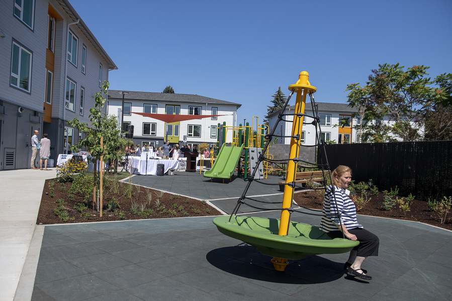 Vancouver Mayor Anne McEnerny-Ogle tests out some of the new playground equipment at Columbia Heights affordable housing complex during its grand opening on Wednesday afternoon.