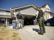 A deputy sheriff assists Clark-Vancouver Drug Task Force members during a drug bust operation in Vancouver.