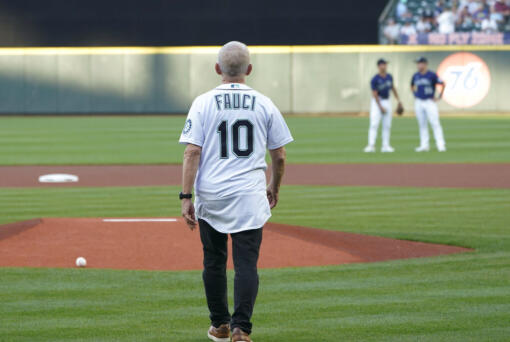Dr. Anthony Fauci walks to the mound to throw out the first pitch before a baseball game between the Seattle Mariners and the New York Yankees, Tuesday, Aug. 9, 2022, in Seattle. Fauci is President Joe Biden's chief medical adviser and director of the National Institute of Allergy and Infectious Diseases. (AP Photo/Ted S.