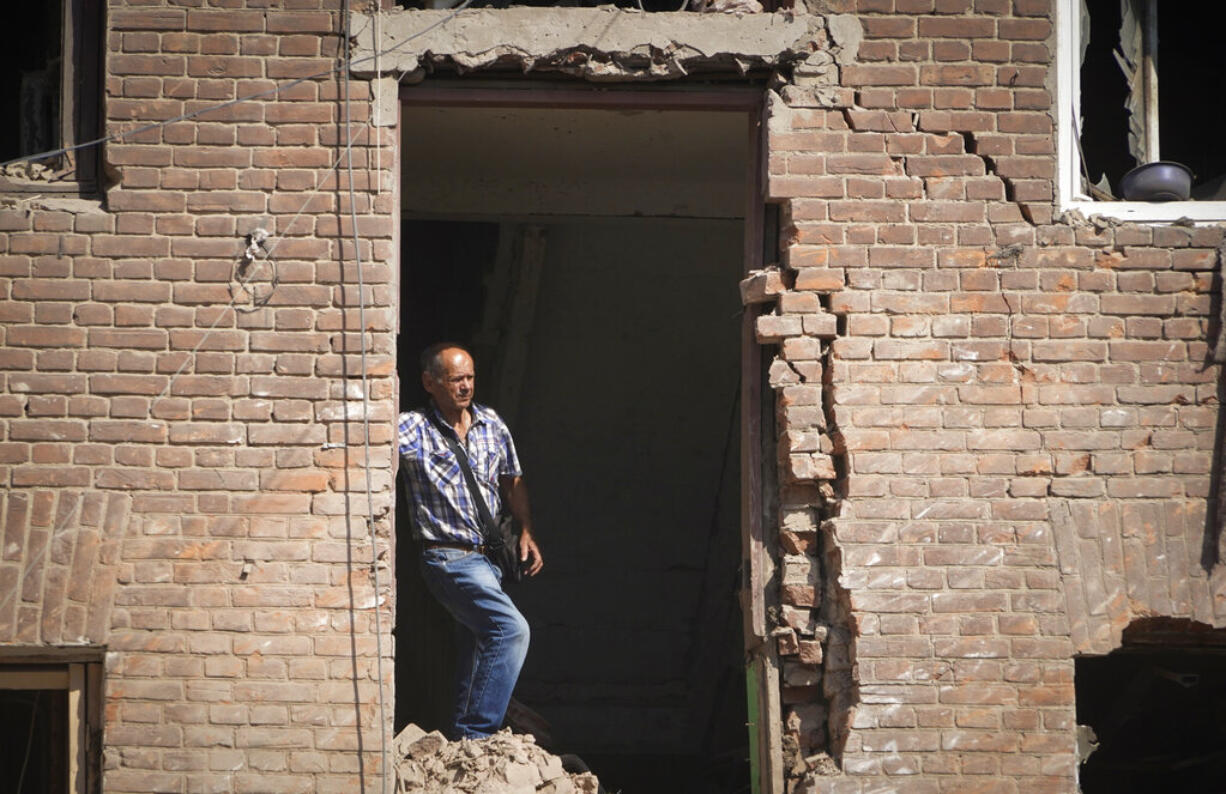 Local resident stands in a building destroyed during a missile strike in Kharkiv, Ukraine, Thursday, Aug. 18, 2022.