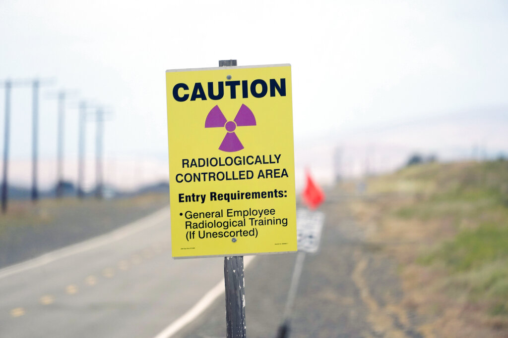 FILE - A caution sign is shown on a road on the Hanford Nuclear Reservation on June 2, 2022. A deal to address two nuclear waste storage tanks that are leaking radioactive materials into the soil on the reservation in Washington state has been reached between Washington state and the U.S. Department of Energy. (AP Photo/Ted S.