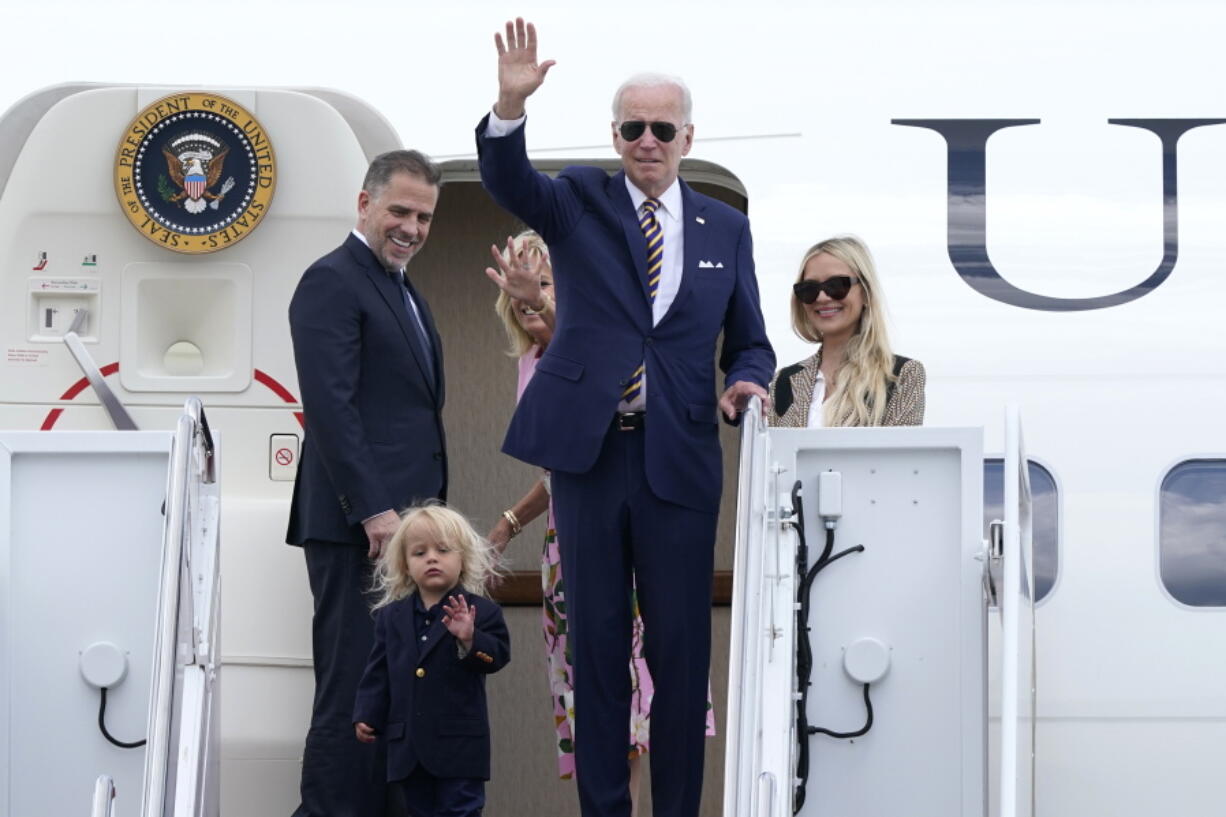 President Joe Biden, center, waves as he is joined by, from left, son Hunter Biden, grandson Beau Biden, first lady Jill Biden, and daughter-in-law Melissa Cohen, as they stand at the top of the steps of Air Force One at Andrews Air Force Base, Md., Wednesday, Aug. 10, 2022. They are heading to South Carolina for a week-long vacation on Kiawah Island.
