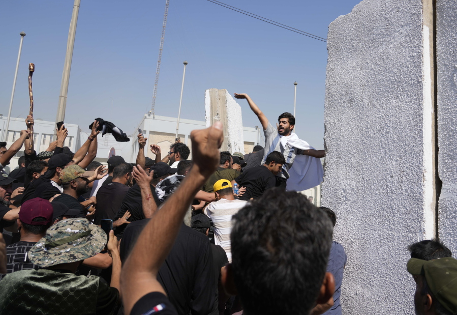 Supporters of Shiite cleric Muqtada al-Sadr try to remove concrete barriers in the Green Zone area of Baghdad, Iraq, Monday, Aug. 29, 2022.
