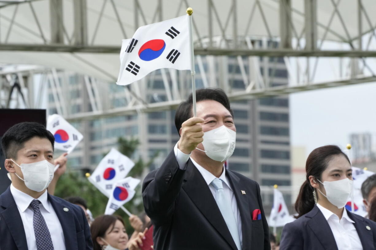 South Korean President Yoon Suk Yeol waves a national flag during a ceremony to celebrate Korean Liberation Day from Japanese colonial rule in 1945, at the presidential office square in Seoul, South Korea, Monday, Aug. 15, 2022.