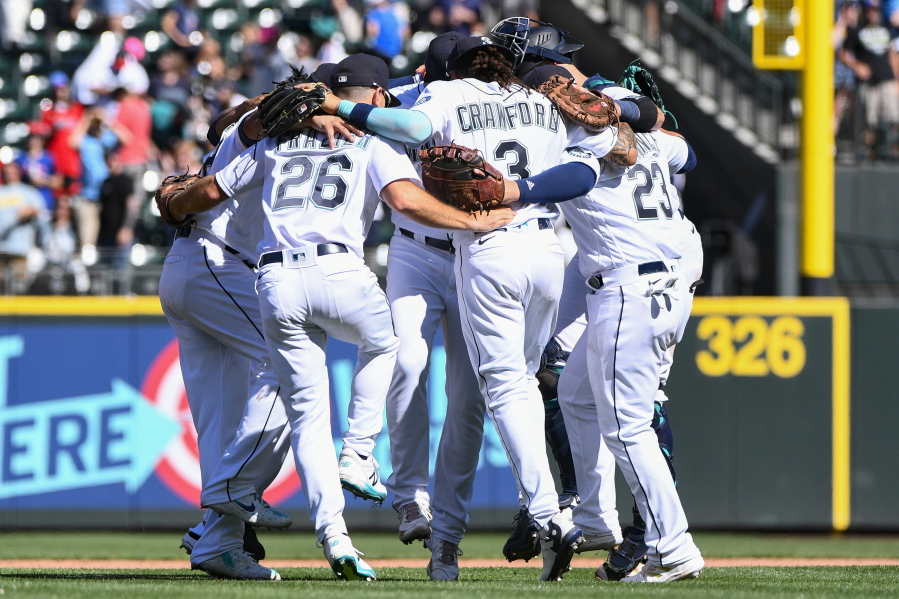 Seattle Mariners players celebrate with a group dance in center field after defeating the Los Angeles Angels in the first game of a baseball doubleheader, Saturday, Aug. 6, 2022, in Seattle.