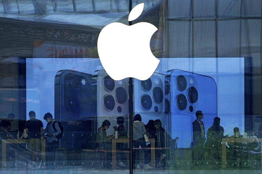 FILE - People shop at an Apple Store in Beijing, Tuesday, Sept. 28, 2021. Apple disclosed serious security vulnerabilities Wednesday, Aug. 17, 2022 for iPhones, iPads and Macs. The software flaws could potentially allow attackers to take complete control of these devices, Apple said.