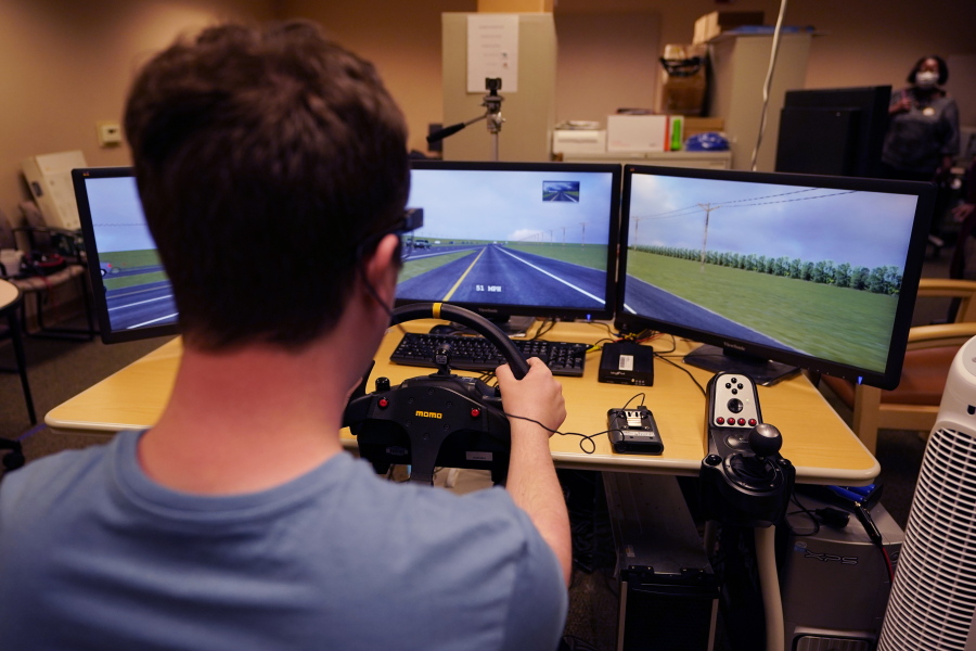 Tate Ellwood-Mielewski test drives on a simulator at the University of Michigan, Friday, April 29, 2022, in Ann Arbor, Mich. Michigan researchers plan to study how well those with autism spectrum disorder detect road hazards and assist the young motorists in sharpening their driving skills. The upcoming effort marks the second phase of a project that is funded by Ford Motor Co. and teams the Ann Arbor university with a local driving school.