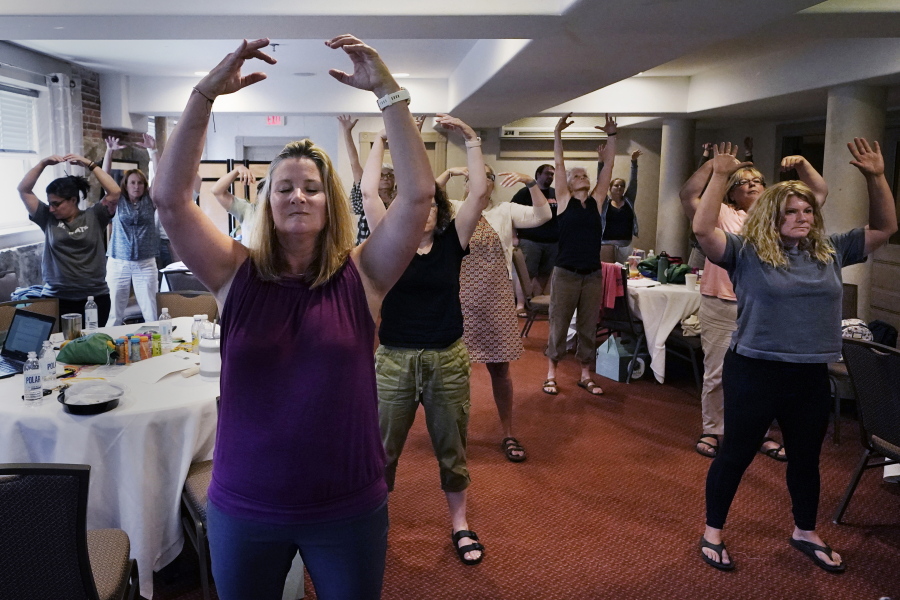 Instructor Emily Daniels, front left, leads a workshop helping teachers find a balance in their curricula while coping with stress and burnout in the classroom on Aug. 2 in Concord, N.H. School districts around the country are starting to invest in programs aimed at addressing the mental health of teachers.