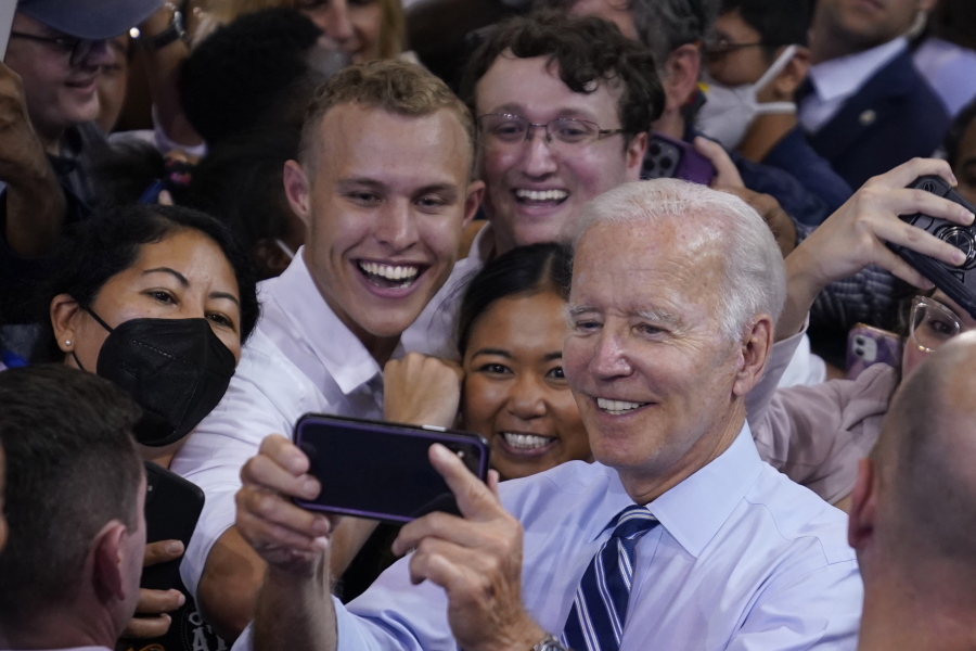 President Joe Biden takes a photo with people after speaking at a rally hosted by the Democratic National Committee at Richard Montgomery High School, Thursday, Aug. 25, 2022, in Rockville, Md.