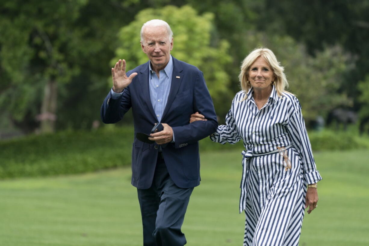 President Joe Biden with first lady Jill Biden waves as they walk on the South Lawn of the White House in Washington, upon arrival from a trip to visit flood affected areas in Kentucky, Monday, Aug. 8, 2022.
