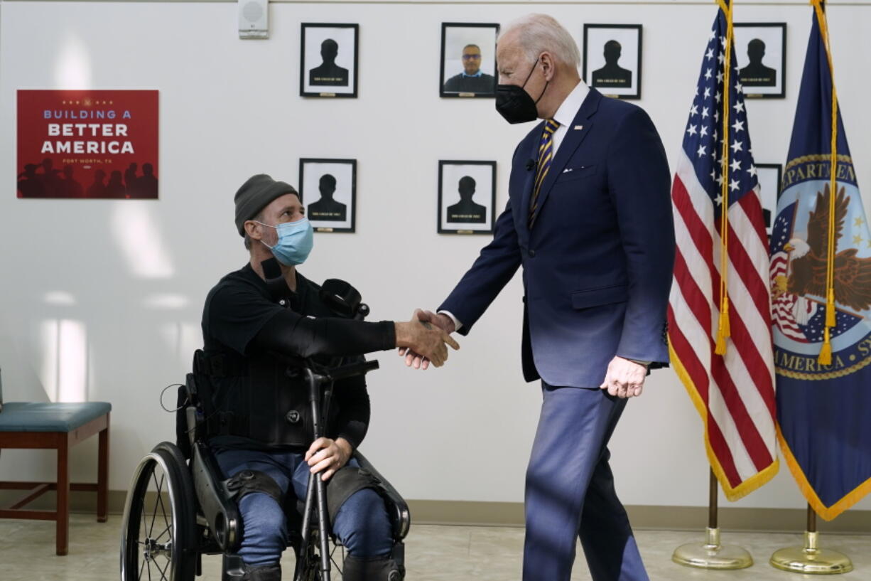 FILE - President Joe Biden shakes hands with veteran John Caruso as Biden tour's the Fort Worth VA Clinic in Fort Worth, Texas, March 8, 2022. Biden will sign veterans health care legislation on Aug. 10, that ends a long battle to expand benefits for people who served near burn pits. It's a personal issue for Biden. His son Beau was a major in the Delaware Army National Guard, and he died of cancer after his service in Iraq.