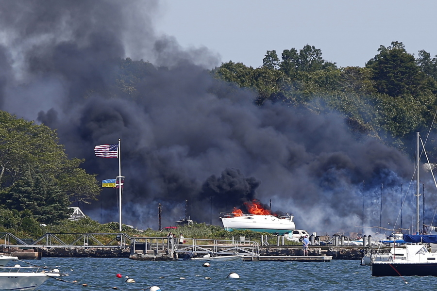 Crews battle a massive fire that has destroyed buildings, cars and vessels at a boat yard in Mattapoisett, Mass., Friday, Aug. 19, 2022.  The area of the fire was part of a Weather Service warning Friday of elevated fire risk due to drought and high winds. It sent a plume of dense black smoke over southeastern Massachusetts.