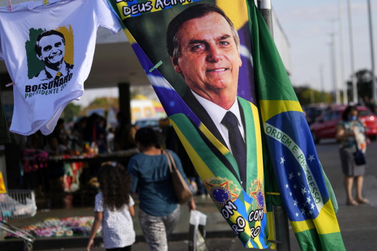 FILE - A banner emblazoned with an image of Brazil's President Jair Bolsonaro, who is a candidate for reelection, is displayed for sale in Brasilia, Brazil, Aug. 2, 2022.  Almost half a century later to the day, thousands are expected to rally on Aug. 11, for the readings of two documents inspired by the original "Letter to the Brazilians". Both new manifestos defend the nation's democratic institutions and electronic voting system, which Bolsonaro has relentlessly attacked ahead of his reelection bid.