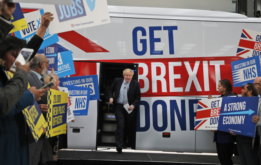 FILE - Britain's Prime Minister Boris Johnson addresses his supporters prior to boarding his General Election campaign trail bus in Manchester, England, Friday, Nov. 15, 2019. The moving vans have already started arriving in Downing Street, as Britain's Conservative Party prepares to evict Johnson. Debate about what mark he will leave on his party, his country and the world will linger long after he departs in September.