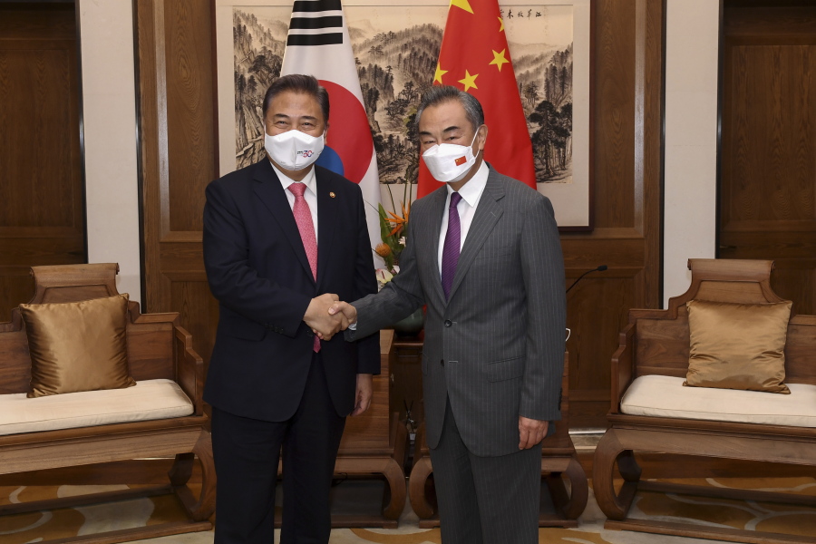 In this photo released by Xinhua News Agency, South Korean Foreign Minister Park Jin, left, shakes hands with his Chinese counterpart Wang Yi before head to their meeting in Qingdao in east China's Shandong province, Tuesday, Aug. 9, 2022. South Korea on Wednesday stressed it will make its own decisions in strengthening its defense against North Korean threats, rejecting Chinese calls to inherit the polices of Seoul's previous government that refrained from adding more U.S. anti-missile batteries that raise security jitters in Beijing.