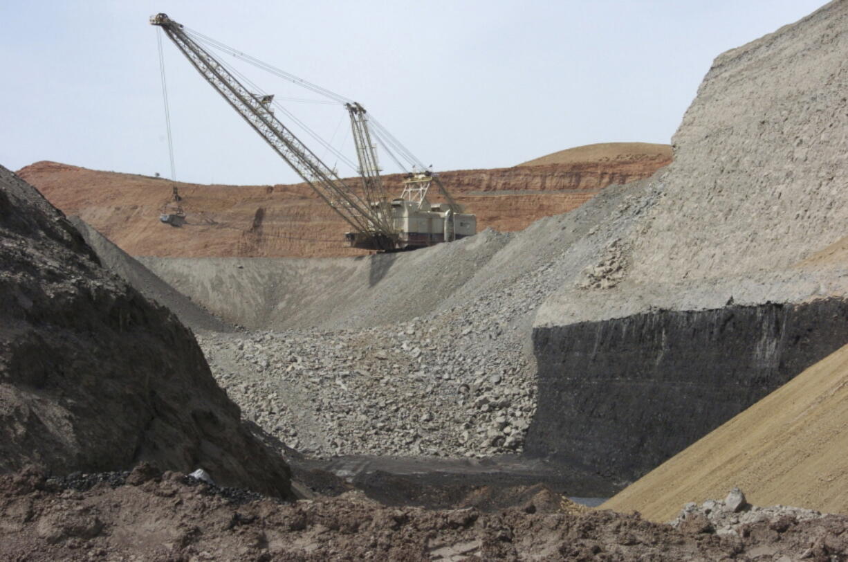 A dragline excavator moves rocks above a coal seam at the Spring Creek Mine in Decker, Mont., in 2013.
