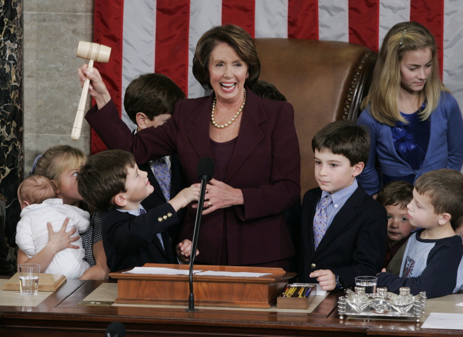 FILE - Newly elected Speaker of the House Nancy Pelosi, holds up the gavel surrounded by children and grandchildren of members of Congress in the U.S. Capitol in Washington, Jan. 4, 2007.