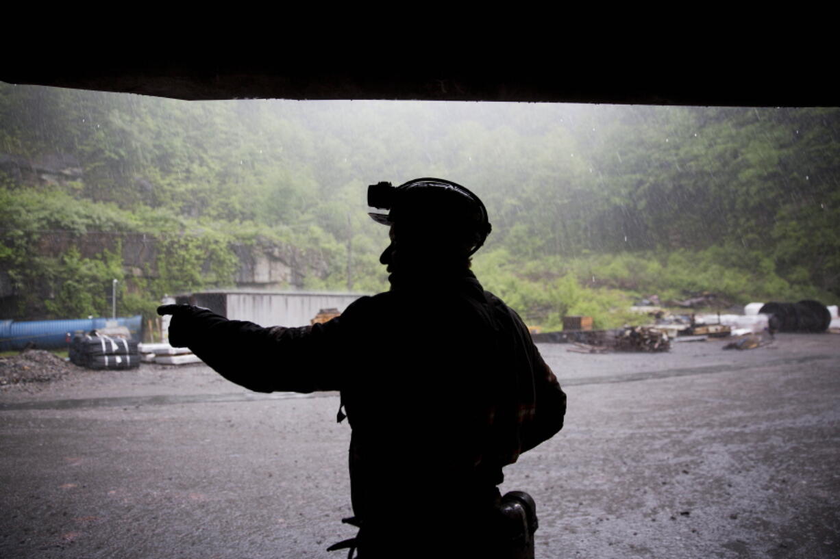 FILE - Coal miner Scott Tiller takes shelter from the rain after coming out of an underground mine at the end of a shift in Welch, W.Va., May 12, 2016. The sprawling economic package passed by the U.S. Senate this week has a certain West Virginia flavor. The bill could be read largely as an effort to help West Virginia look to the future without turning away entirely from its roots.
