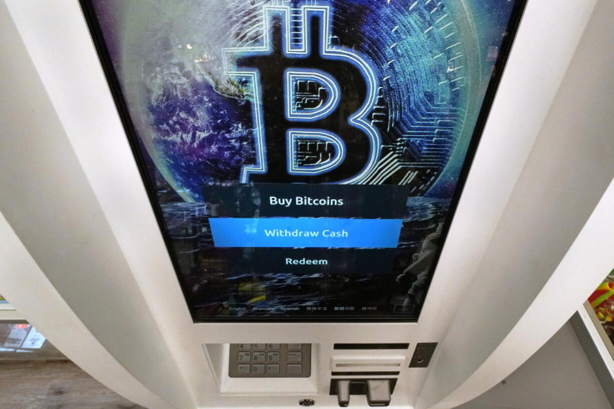 FILE - The Bitcoin logo appears on the display screen of a cryptocurrency ATM in Salem, N.H., Feb. 9, 2021. A bipartisan group of senators has proposed a bill to regulate cryptocurrencies. It's the latest attempt by Congress to formulate ideas on how to oversee a multibillion-dollar industry that has been racked recently by collapsing prices and lenders halting operations.