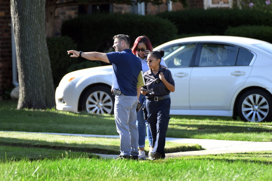 Detroit Police and investigators look over a shooting scene on Pennington Drive, north of Seven Mile Road, Sunday, Aug. 28, 2022, in Detroit. Four people were shot, with fatalities, by a person who appeared to be firing at people randomly over a roughly 2 1/2-hour period Sunday morning in Detroit, police said.