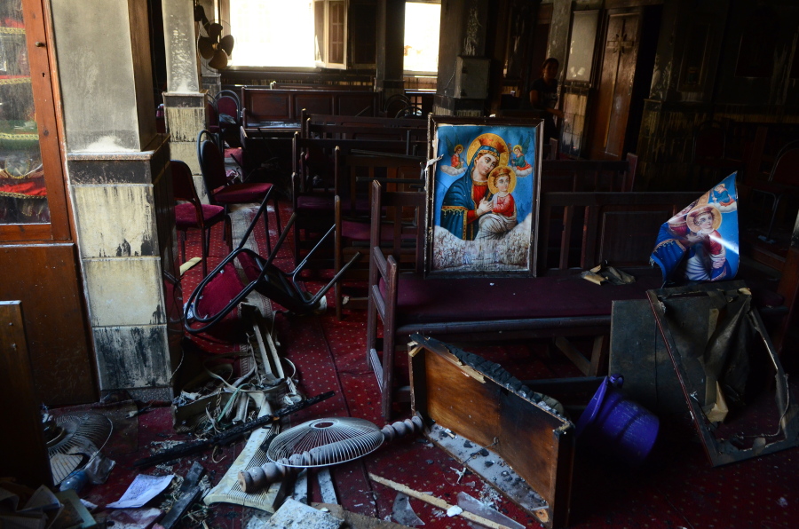 Burned furniture, including wooden tables and chairs, and a religious images are seen at the site of a fire inside the Abu Sefein Coptic church that killed at least 40 people and injured some 14 others, in the densely populated neighborhood of Imbaba, Cairo Egypt, Sunday, Aug. 14, 2022. The church said the fire broke out while a service was underway. The cause of the blaze was not immediately known. An initial investigation pointed to an electrical short-circuit, according to a police statement.
