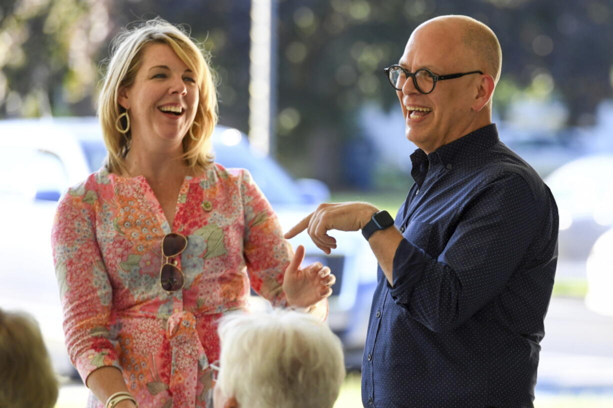 Ohio House Democratic Leader Allison Russo, left, and Ohio House House District 89 Candidate Jim Obergefell, right, laugh during a meeting of the Democratic Women of Erie County at Strickfaden Park, Monday, July 18, 2022, in Sandusky, Ohio. Obergefell is hoping that Democrats can win back seats at the Ohio Statehouse and beyond this fall with a message grounded in his landmark U.S. Supreme Court fight for same-sex marriage.