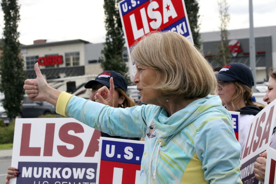 U.S. Sen. Lisa Murkowski, an Alaska Republican, flashes a thumbs-up to a passing motorist while waving signs, Tuesday, Aug. 16, 2022, in Anchorage, Alaska. Murkowski faces 18 challengers in the state's open primary for U.S. Senate, in which the top four vote-getters regardless of party affiliation will advance to the November general election.