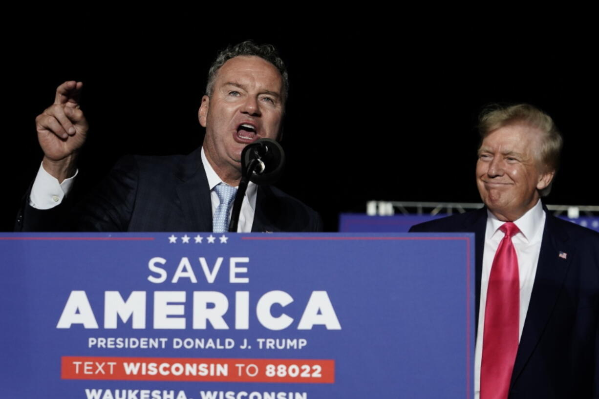 FILE - Wisconsin Republican gubernatorial candidate Tim Michels, left, speaks as former President Donald Trump, right, listens at a rally Aug. 5, 2022, in Waukesha, Wis. Michels casts himself as an outsider, although he previously lost a campaign to oust then-U.S. Sen. Russ Feingold in 2004 and has long been a prominent GOP donor.