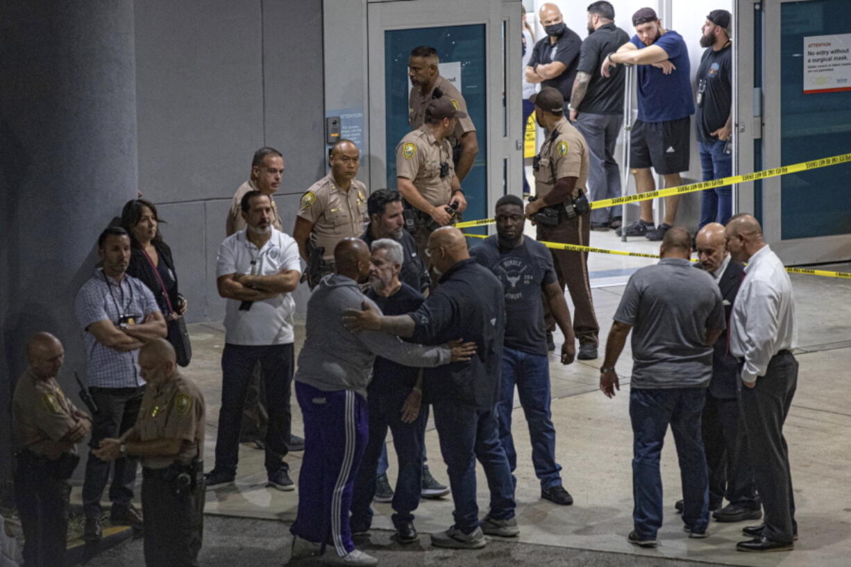 Police officers and other officials stand outside the Ryder Trauma Center after a Miami-Dade police officer was shot in an exchange of gunfire during a car chase with an armed robbery suspect, Monday, Aug. 15, 2022, in Miami.