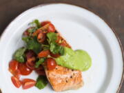This image released by Milk Street shows a recipe for salmon with avocado sauce and tomato-cilantro salsa.