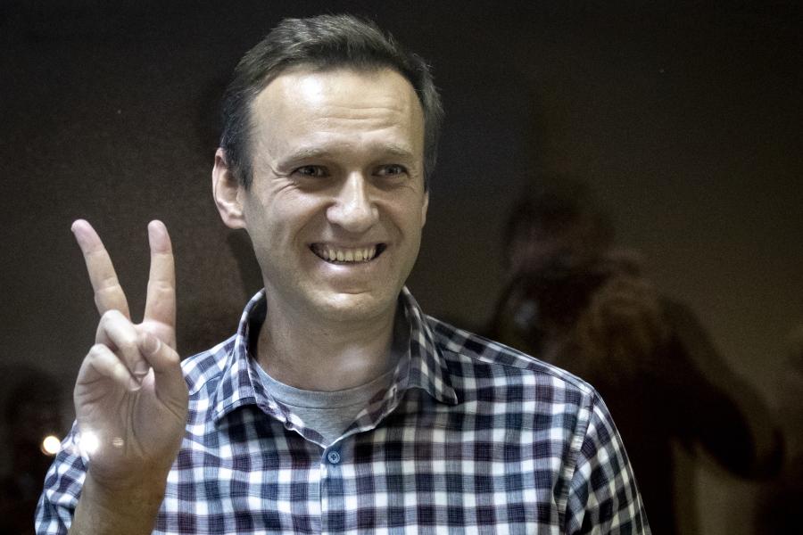 FILE -- Russian opposition leader Alexei Navalny gestures as he stands behind a glass panel of a cage in the Babuskinsky District Court in Moscow, Russia, Saturday, Feb. 20, 2021. On the second anniversary of the poison attack on Alexei Navalny, Germany and the United States have recalled the fate of Kremlin critic Alexei Navalny who is imprisoned in Russia. German Chancellor Olaf Scholz praised the Russian opposition politician's courage in a video message Saturday.