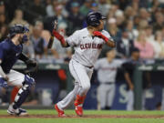 Cleveland Guardians' Jose Ramirez, right, watches his RBI-double against the Seattle Mariners during the eighth inning of a baseball game, Saturday, Aug. 27, 2022, in Seattle.