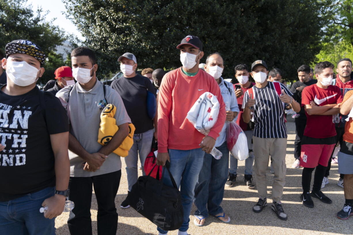 FILE - Migrants hold Red Cross blankets after arriving at Union Station near the U.S. Capitol from Texas on buses, April 27, 2022, in Washington.  The Pentagon has rejected a request from the District of Columbia seeking National Guard assistance for the thousands of migrants being bused to the city from two southern states.