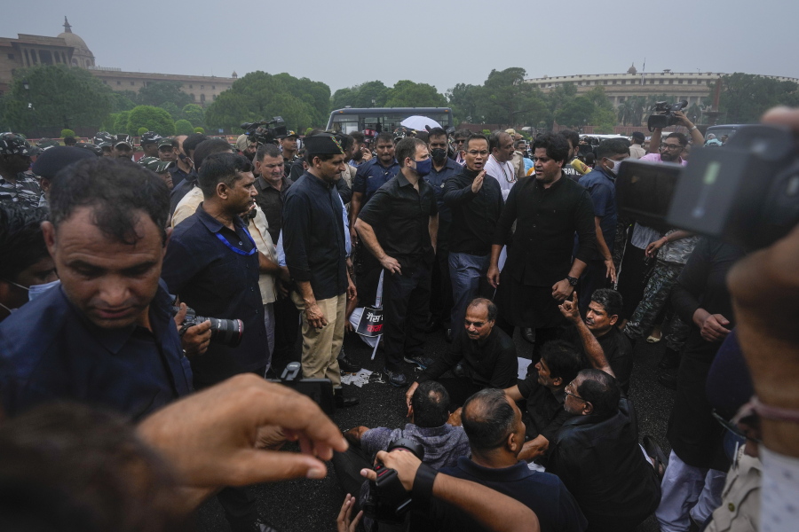 Congress party leader Rahul Gandhi, center in blue mask, and other lawmakers participate in a protest in New Delhi, India, Friday, Aug. 5, 2022. "Democracy is a memory (in India)," Gandhi later tweeted, describing the dramatic photographs that showed him and his party men being briefly detained by police.