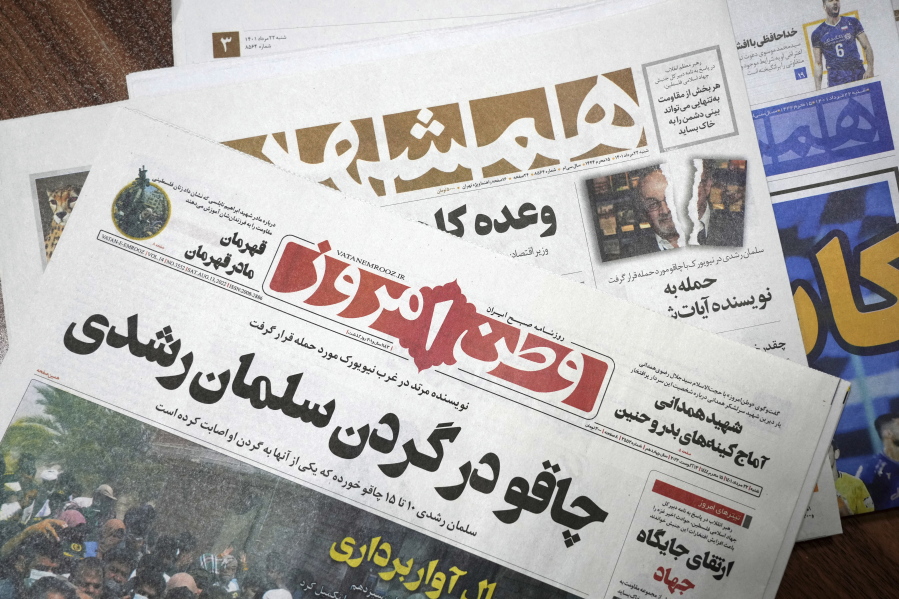 The front pages of the Aug. 13 edition of the Iranian newspapers, Vatan-e Emrooz, front, with title reading in Farsi: "Knife in the neck of Salman Rushdie," and Hamshahri, rear, with title: "Attack on writer of Satanic Verses," are pictured in Tehran Saturday, Aug. 13, 2022. Rushdie, whose novel "The Satanic Verses" drew death threats from Iran's leader in the 1980s, was stabbed in the neck and abdomen Friday by a man who rushed the stage as the author was about to give a lecture in western New York.