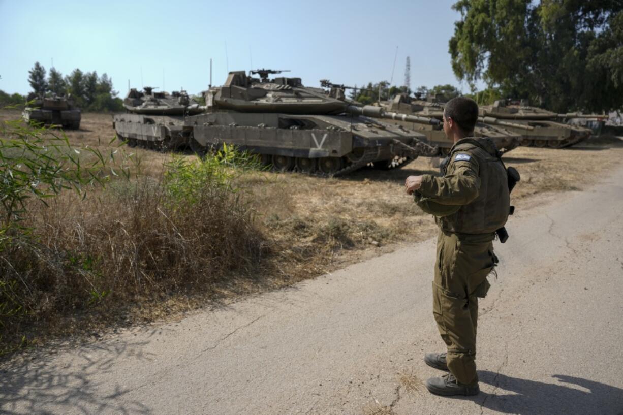 An Israeli soldier secures tanks in an area near the border with Gaza Strip, Friday, Aug. 5, 2022. Israel has closed roads near Gaza and sent in troop reinforcements as it braces for a possible revenge attack, following the arrest of a senior Palestinian militant in the occupied West Bank earlier this week.