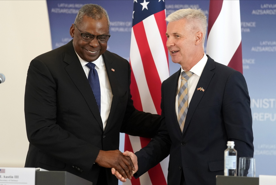 U.S. Secretary of Defense Lloyd Austin, left, and Latvian Minister of Defence Artis Pabriks shake hands during the press conference in Riga, Latvia, Wednesday, Aug. 10, 2022.