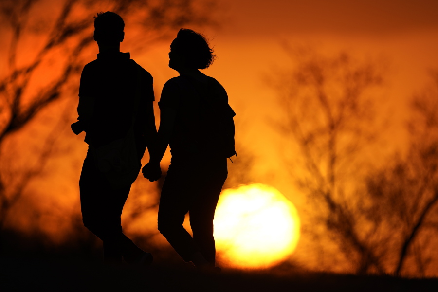 FILE - In this March 10, 2021 file photo, a couple walks through a park at sunset in Kansas City, Mo. U.S. life expectancy dropped for two consecutive years in 2020 and 2021, marking the first such trend since the early 1920s, according to a new government report.