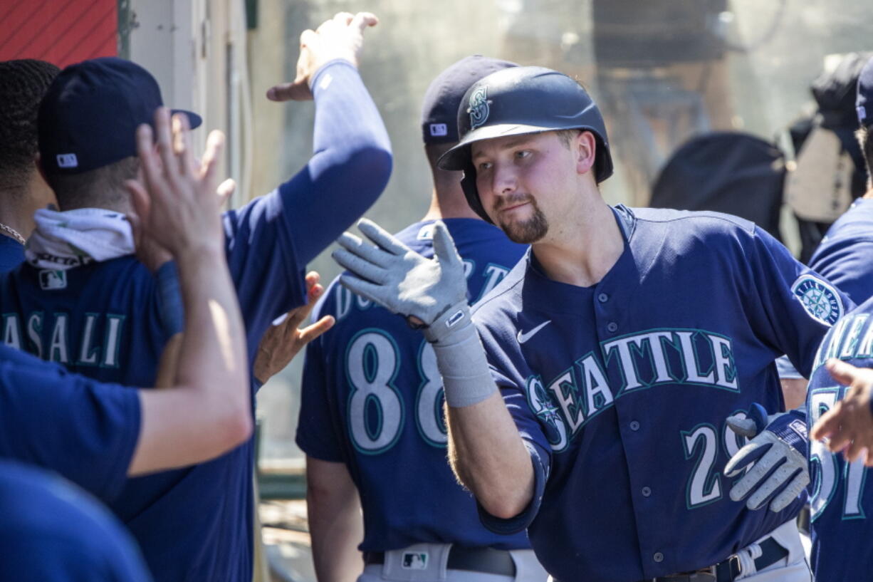 Seattle Mariners' Cal Raleigh celebrates with teammates after hitting a solo home run against the Los Angeles Angels during the fifth inning of a baseball game in Anaheim, Calif., Wednesday, Aug. 17, 2022.