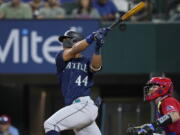 Seattle Mariners' Julio Rodriguez (44) follows through on a two-run single next to Texas Rangers catcher Jonah Heim during the fourth inning.