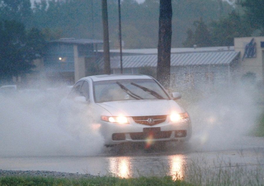 A driver drives through high water on Dale Drive in Marion, Miss., on Wednesday, Aug. 24, 2022. Parts of Mississippi received several inches of rain throughout the day.