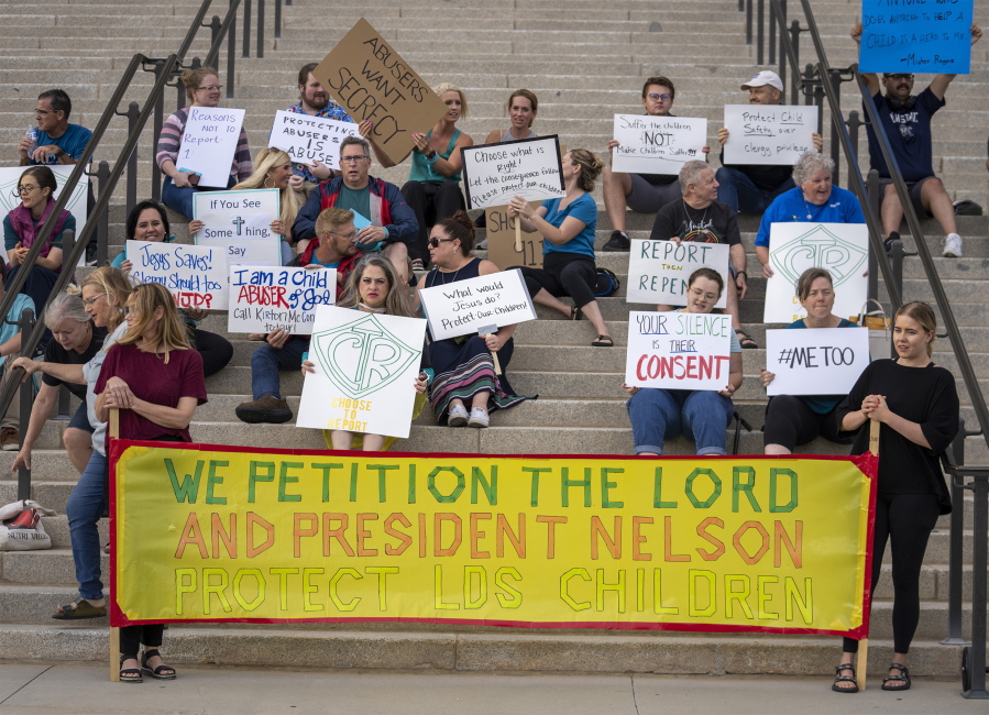 Protesters gather on the steps of the Utah State Capitol, at a rally to gain support for removing the clergy exemption from mandatory reporting in cases of abuse and neglect, on Friday, Aug. 19, 2022 in Salt Lake City. Demonstrators gathered outside the Utah Capitol on Friday to demand lawmakers remove an exemption from state law that frees religious leaders from being required to report sexual abuse when perpetrators mention it in confessions.