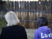 MJ and her adoptive mother sit for an interview with The Associated Press in Sierra Vista, Ariz., Oct. 27, 2021. State authorities placed MJ in foster care after learning that her father, the late Paul Adams, sexually assaulted her and posted video of the assaults on the Internet.