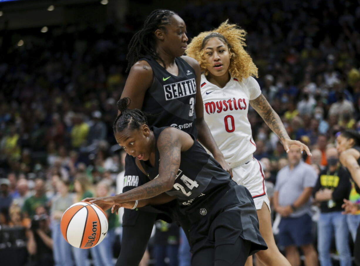 Seattle Storm guard Jewell Loyd (24) gets the rebound and makes a break around Storm center Tina Charles (31) as Washington Mystics center Shakira Austin (0) watches during the first half of Game 1 of a WNBA basketball first-round playoff series Thursday, Aug. 18, 2022, in Seattle.