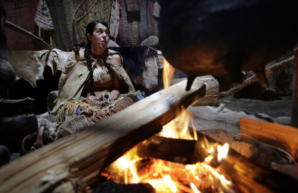 Mashpee Wampanoag Kerri Helme, of Fairhaven, Mass., uses plant fiber to weave a basket while sitting next to a fire on November 15, 2018, at the Wampanoag Homesite at the Plimoth Patuxet Museums, in Plymouth, Mass. Native Americans in Massachusetts are calling for a boycott of a popular living history museum featuring colonial reenactors portraying life in Plymouth, the famous English settlement founded by Pilgrims arriving on the Mayflower. They say the Plimoth Patuxet museum hasn't lived up to its mandate to create a "bi-cultural museum" telling equally the stories of the European and indigenous communities.